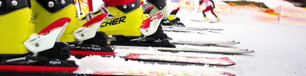 Skischuhe in Bindungen auf Skiern, bereit für den nächsten Kurstag.